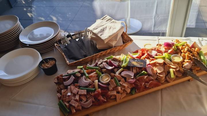 Charcuterieschotel op een feest, met een stapel borden ernaast