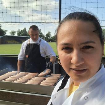 Georgiana vooraan, John aan de grill op een clubfeest