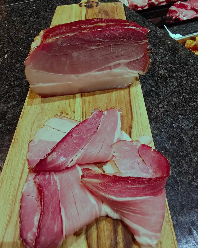 Gerookt spek, gesneden op een houten plank