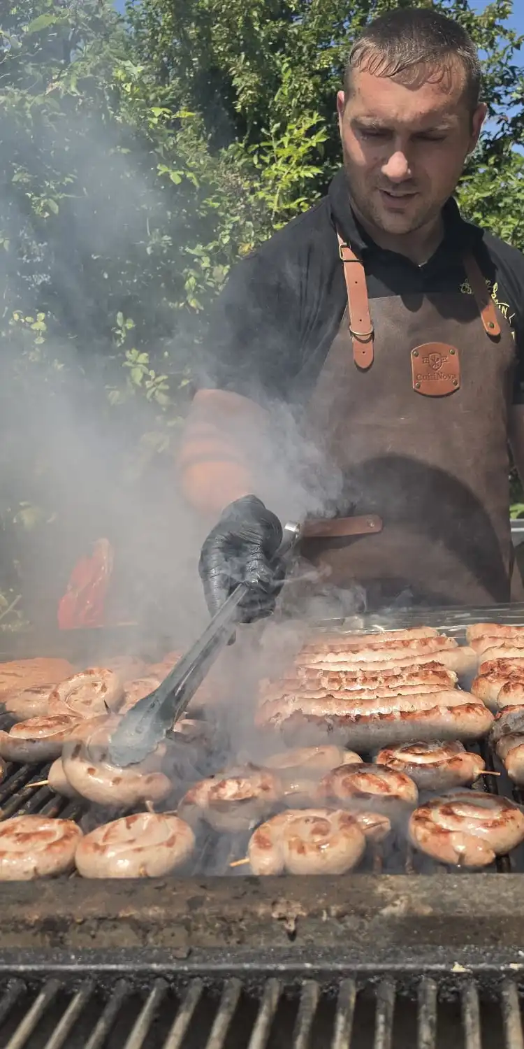 John aan de barbecue, worsten op de grill