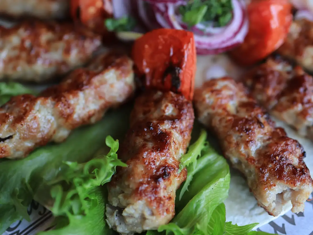 Mici la grătar pe salată, cu ceapă roșie și ardei