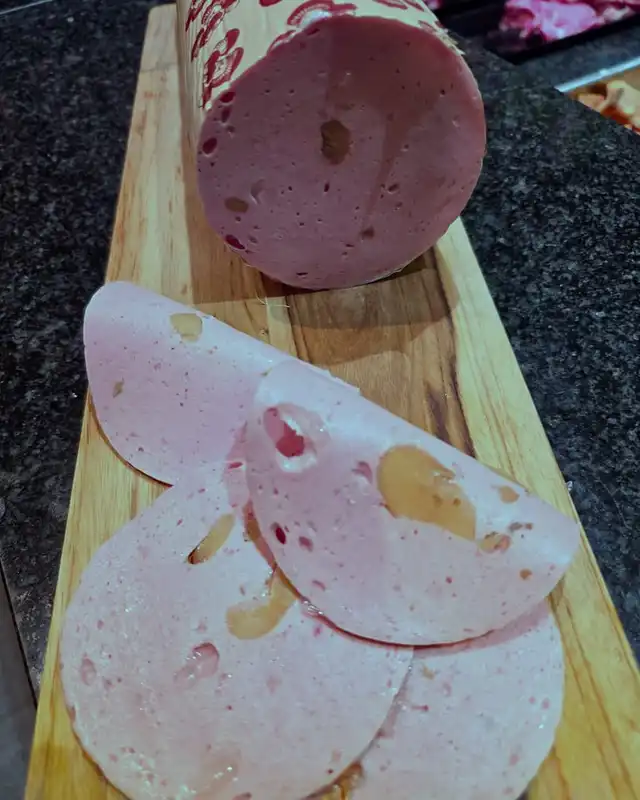 Parizer (Roemeense kookworst), gesneden op een houten plank