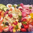 Platou românesc festiv: ouă umplute, salam, brânză, ruladă și legume
