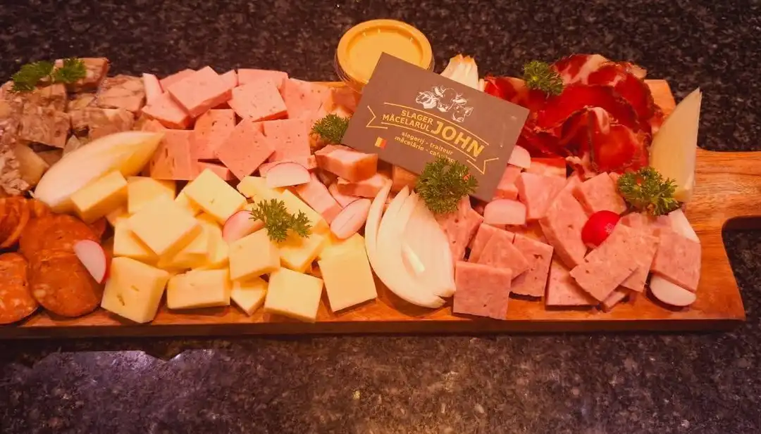 Roemeense tapas: kaas, salami, worst en ui op een houten plank