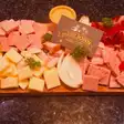 Tapas românești: brânză, salam, cârnați și ceapă pe o planșetă de lemn