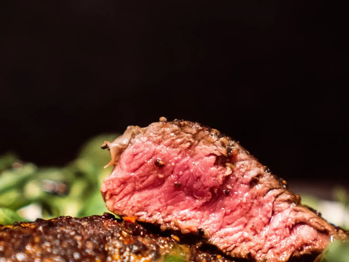 Carne de vită rozé, feliată, pe frunze de salată