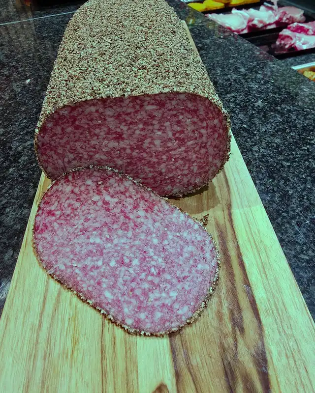Salami met peperkorst, gesneden op een houten plank