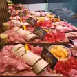 Tapas John 1 cu scampi: wrapuri, șuncă și salam pe o planșetă de lemn, în vitrină