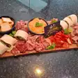 Tapas mix pe un platou de lemn, cu wrapuri și sosuri